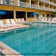 Outdoor Pool With Chaise Lounge Chairs at the Best Western Ocean Beach Hotel & Suites in Cocoa Beach, Florida. Watch your children play during your Family Summer Vacation.